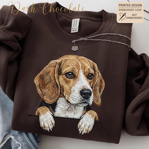 Könnte beinhalten: Dunkelbraunes Sweatshirt mit einem Stickerei-Look Beagle-Hund-Design. Der Hund hat braunes und weißes Fell und eine schwarze Nase, die aus einem taschenartigen Detail hervorschaut. Der Text "Dark Chocolate" befindet sich oben.
