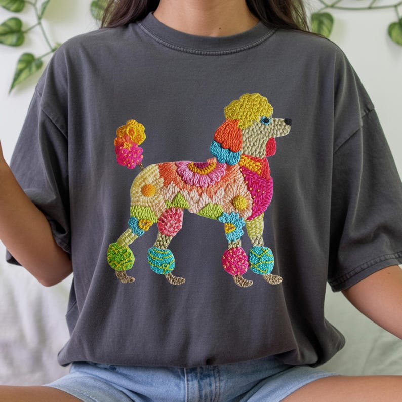 Pu&ograve; includere: T-shirt grigio scuro con un design di barboncino ricamato e colorato. Il barboncino presenta vivaci motivi floreali nei toni del giallo, arancione, rosa, verde e blu. La maglietta ha una vestibilit&agrave; ampia e maniche corte.