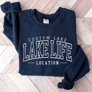 May include: Navy blue sweatshirt with white text that reads "CUSTOM LAKE LAKE LIFE LOCATION".
