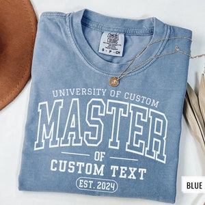 May include: A blue jean t-shirt with the text "UNIVERSITY OF CUSTOM MASTER OF CUSTOM TEXT EST. 2024" printed in white.
