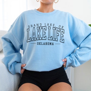 May include: Light blue sweatshirt with black text that reads "Grand Lake, OK Lake Life Oklahoma".