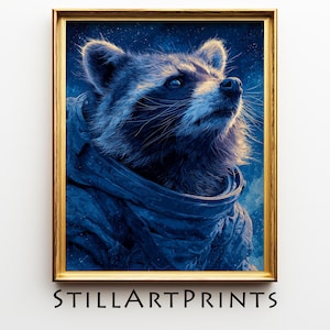 May include: A framed art print featuring a raccoon in a blue space suit, gazing upwards against a starry background. The artwork is in a gold frame, with the text "STILLARTPRINTS" at the bottom.