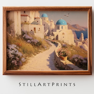 May include: A framed print of a scenic village with white buildings, blue domes, and a winding path. The artwork features a warm color palette with a focus on the architecture and landscape. The text "STILLARTPRINTS" is at the bottom.
