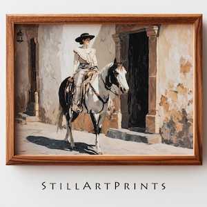 Op de afbeelding: Een ingelijste prent van een schilderij dat een persoon te paard in een historische setting afbeeldt. De persoon draagt een hoed en rijdt op een zwart-wit paard. De achtergrond toont een gebouw met een deuropening en een straat. De tekst "STILLARTPRINTS" staat onderaan.