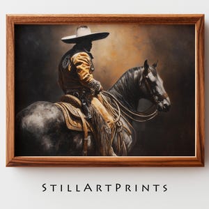May include: A framed print featuring a rider on horseback, dressed in traditional attire. The rider wears a wide-brimmed hat and a yellow jacket. The horse is dark gray, and the artwork has a warm, earthy color palette. The text "STILLARTPRINTS" is at the bottom.