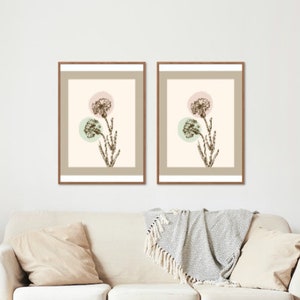 Könnte beinhalten: Zwei gerahmte Drucke mit einer botanischen Illustration einer Blume mit rosa und grünen Kreisen im Hintergrund.