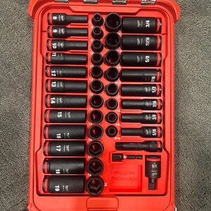 Könnte beinhalten: Eine rote Werkzeugkiste mit transparentem Deckel, gefüllt mit schwarzen Steckschlüsseln und Verlängerungen. Die Steckschlüssel sind mit Größen von 8 bis 19 beschriftet, und auch Bruchteile wie 3/4, 11/16, 5/8, 1/2, 7/16, 3/8 und 5/16 Zoll (ca. 0,8 bis 1,9 cm) sind sichtbar.