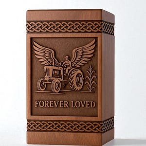 May include: A wooden urn with a carved design. The central panel features a tractor with a person driving, wings, and the words "FOREVER LOVED." Intricate Celtic knotwork borders the top and bottom. The wood has a warm, brown tone.