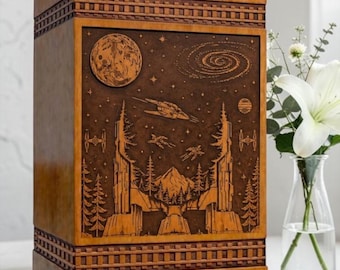 May include: A rectangular wooden urn with a medium brown finish featuring a laser-engraved scene on the front panel. The design depicts a space landscape with a moon, a galaxy, starships, and a forest with mountains. The top and bottom edges have a decorative grid pattern.