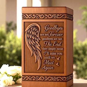 May include: Wooden urn with engraved wing design and the words "Goodbyes are not Forever." The rectangular box has decorative scrollwork around the top and bottom. A touching memorial for a loved one.