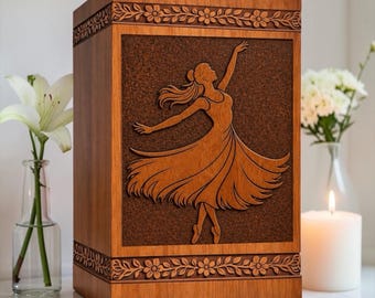 May include: A rectangular wooden cremation urn featuring a dark brown, textured central panel with a carved silhouette of a dancing figure in a flowing dress. The top and bottom borders are decorated with a carved floral vine pattern.