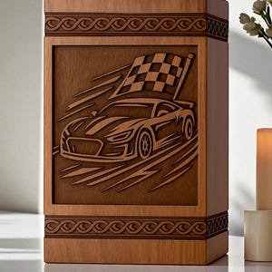 May include: Wooden urn with a carved racing car design. The car is depicted with a checkered flag, suggesting a theme of speed and competition. The urn has decorative borders and a rectangular shape, suitable for memorial purposes.