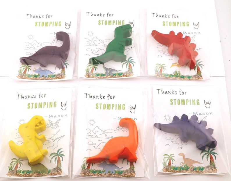 May include: Six dinosaur-shaped crayons in various colors, including purple, green, red, yellow, orange, and blue. Each crayon is packaged with a card that reads "Thanks for stomping by!" and the name "Mason".