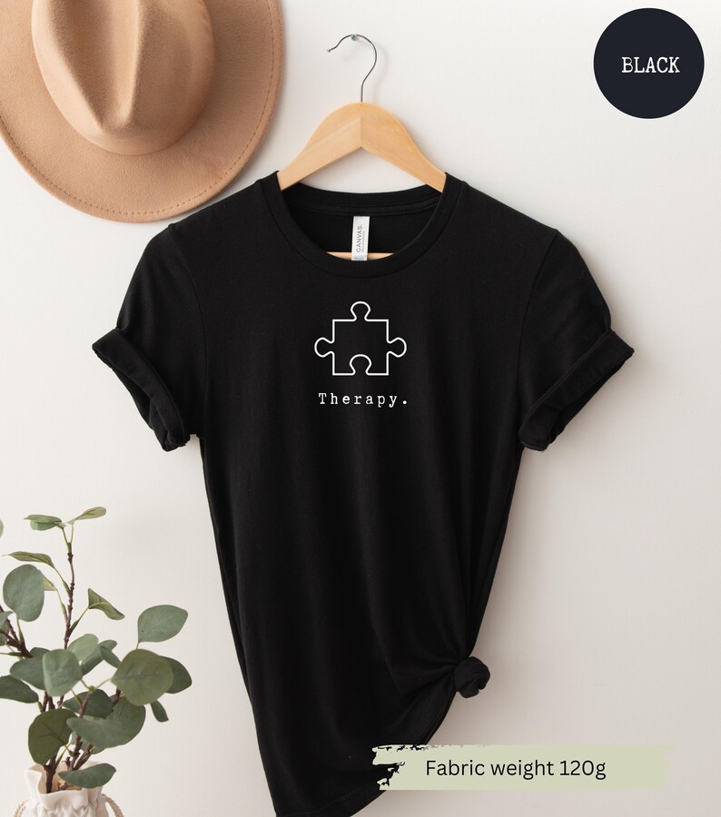 This black t-shirt has a white image of a puzzle piece centred in the middle, with the word therapy underneath. Tailored towards people who enjoy puzzles also who find puzzles a form of therapy.
