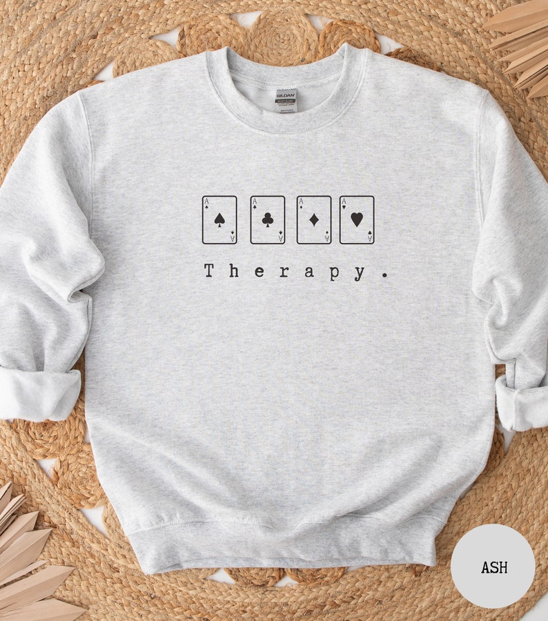 This ash sweatshirt has a black image of a playing cards centred in the middle, with the word therapy underneath. Tailored towards people who enjoy playing cards also who find card games a form of therapy