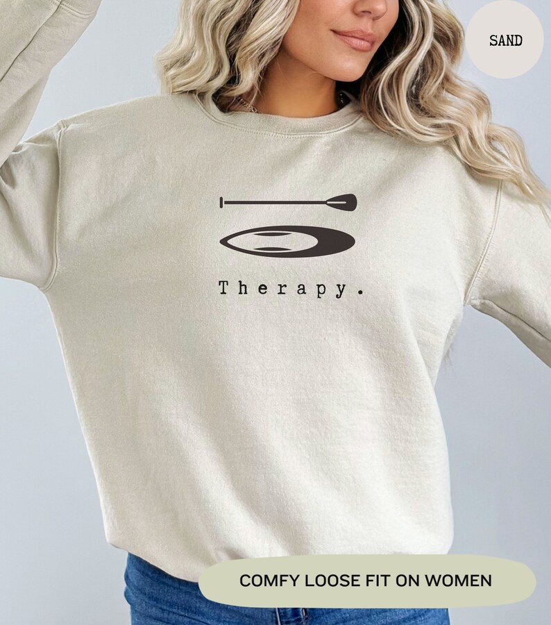 This sand sweatshirt has a black image of a sup board centred in the middle, with the word therapy underneath. Tailored towards people and couples who enjoy sup boarding also who find sup boarding a form of therapy.