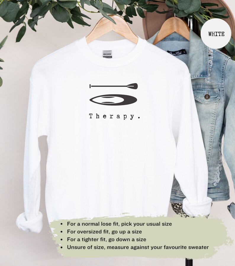 This white sweatshirt has a black image of a sup board centred in the middle, with the word therapy underneath. Tailored towards people and couples who enjoy sup boarding also who find sup boarding a form of therapy.