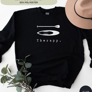 This black sweatshirt has a white image of a sup board centred in the middle, with the word therapy underneath. Tailored towards people and couples who enjoy sup boarding also who find sup boarding a form of therapy.