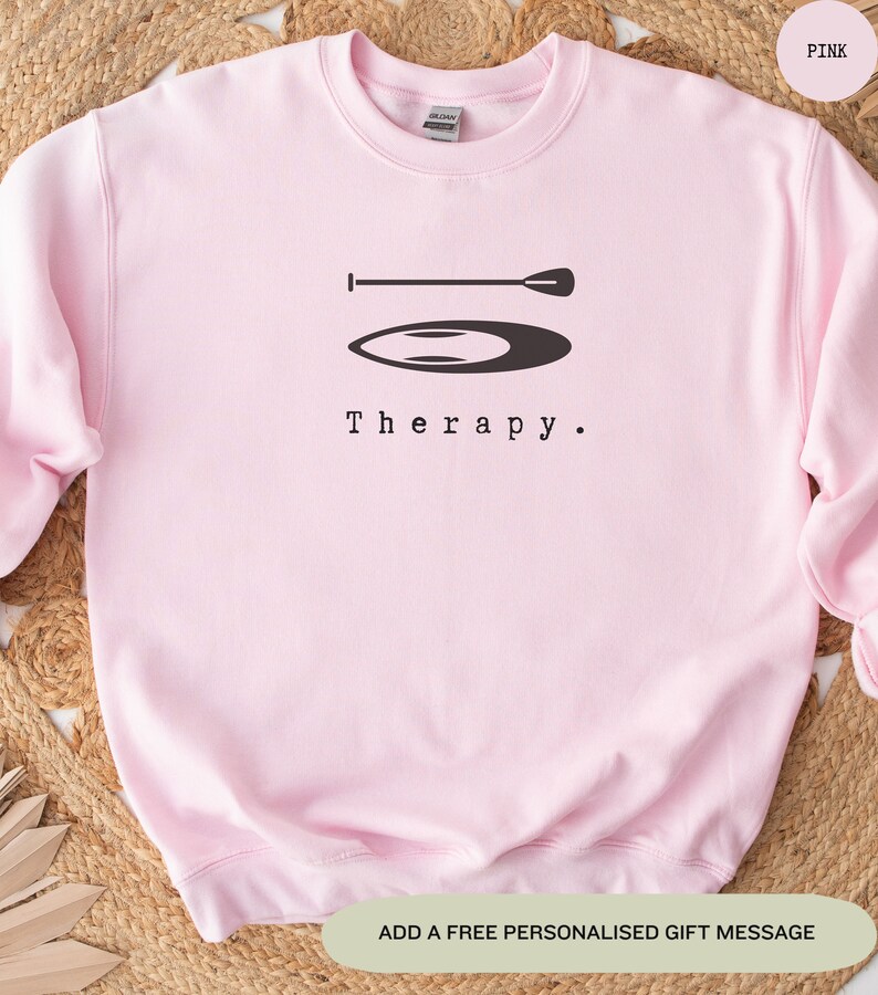 This pink sweatshirt has a black image of a sup board centred in the middle, with the word therapy underneath. Tailored towards people and couples who enjoy sup boarding also who find sup boarding a form of therapy.