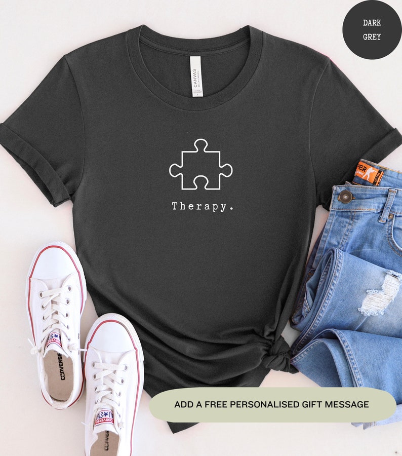 This dark grey t-shirt has a white image of a puzzle piece centred in the middle, with the word therapy underneath. Tailored towards people who enjoy puzzles also who find puzzles a form of therapy.