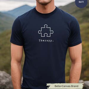 This navy t-shirt has a white image of a puzzle piece centred in the middle, with the word therapy underneath. Tailored towards people who enjoy puzzles also who find puzzles a form of therapy.