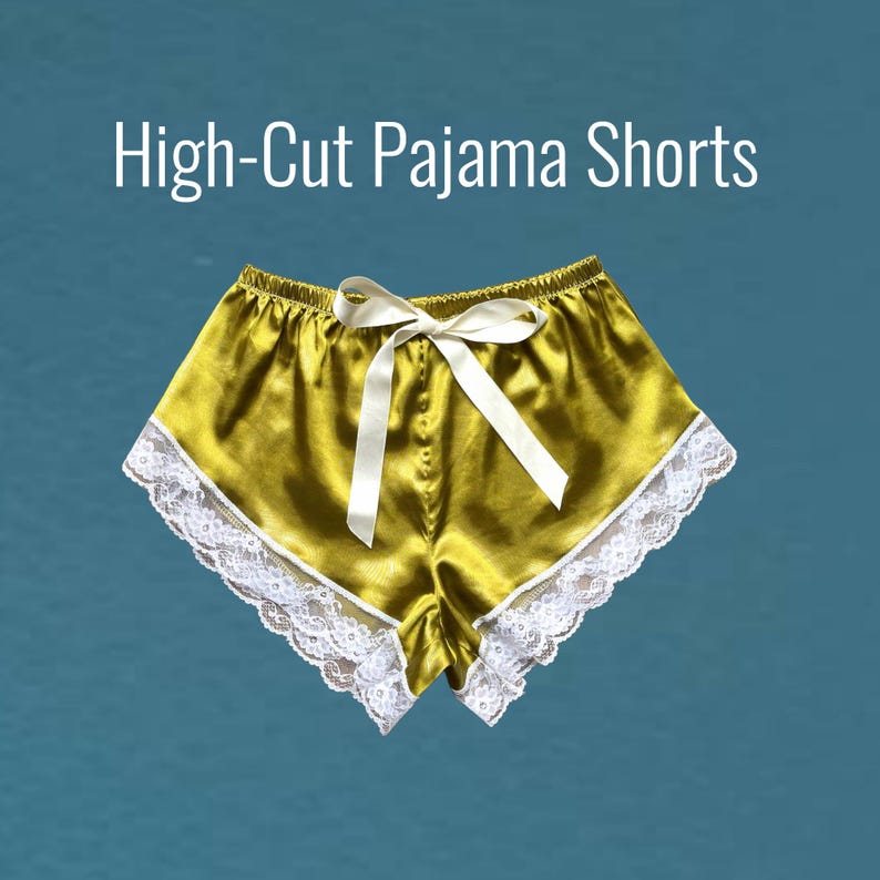 May include: High-cut satin pajama shorts with white lace trim and a satin bow.