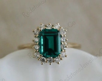 Anillo de aniversario con moissanita verde talla esmeralda y halo de diamantes.