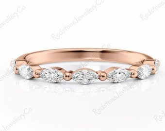 May include: A delicate rose gold band with a row of marquise-shaped diamonds set in a pave setting.