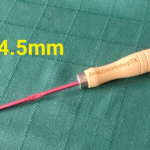 May include: A 4.5 mm crochet hook with a wooden handle. The handle is engraved with "JandJworkshopTX".