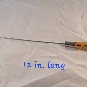 May include: A 12-inch long, silver metal hook tool with a wooden handle. The handle is engraved with "JandJworkshopTX".