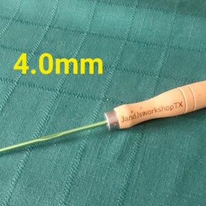 May include: A green and wooden crochet hook with a wooden handle. The handle is labeled "JandJworkshopTX". The hook is 4.0mm.