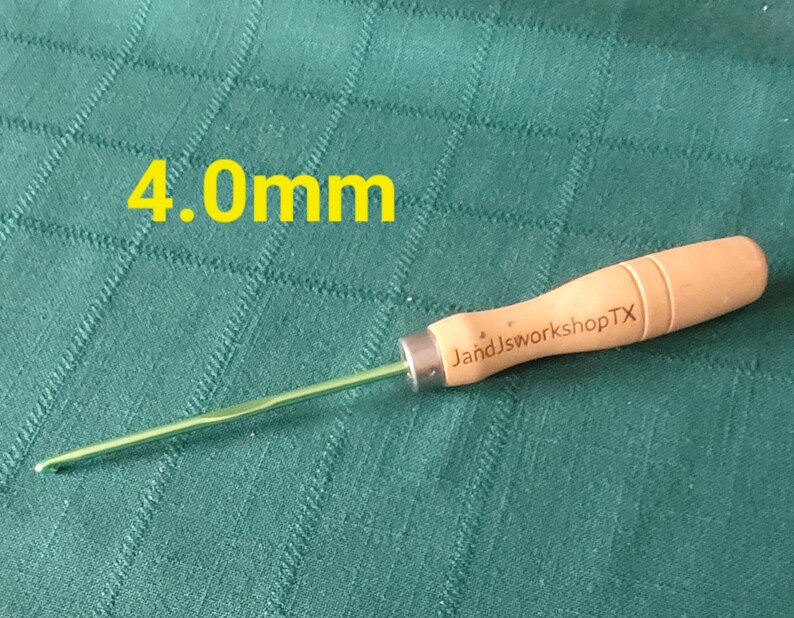 May include: A green and wooden crochet hook with a wooden handle. The handle is labeled "JandJworkshopTX". The hook is 4.0mm.
