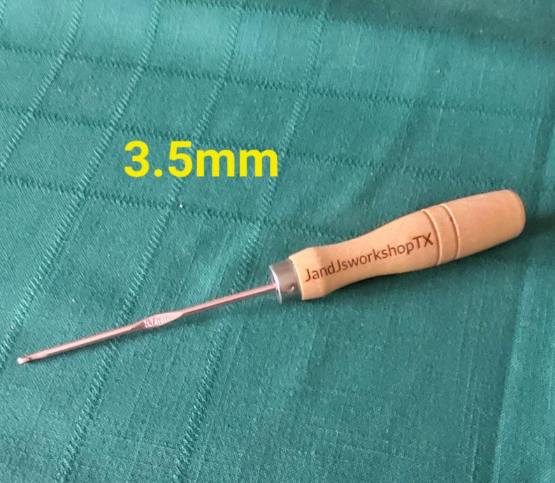 May include: A 3.5 mm crochet hook with a wooden handle. The handle is engraved with "JandJworkshopTX".