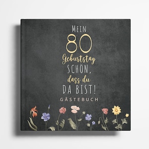 Puede incluir: Una pizarra negra con texto blanco que dice "Mein 80 Geburtstag Schön, dass du da bist! Gästebuch". La pizarra está decorada con un borde floral de flores rosas, amarillas y azules.