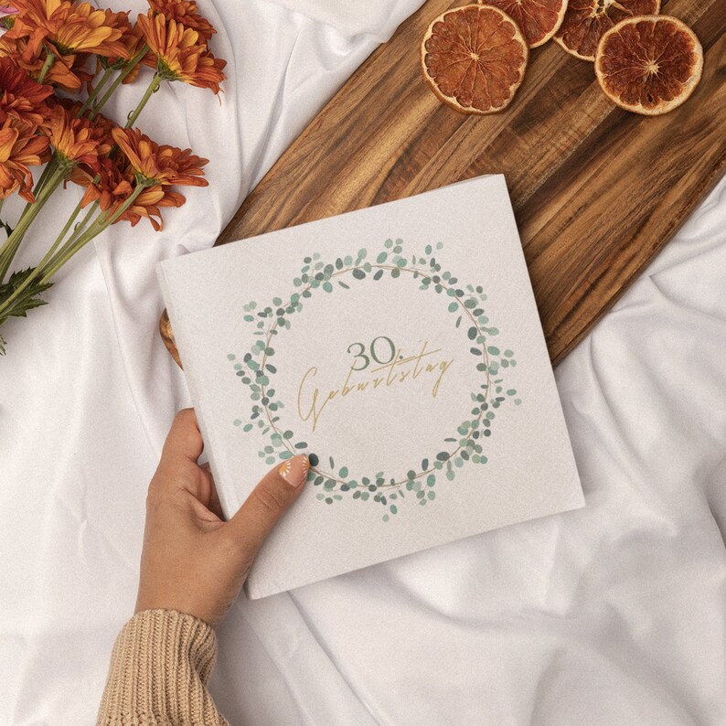 May include: A white card with a green leafy wreath design and the text "30. Geburtstag" in gold lettering.