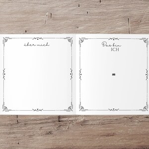May include: A blank white book with a decorative black border. The left page has the text "&uuml;ber mich" and the right page has the text "Das bin ICH".