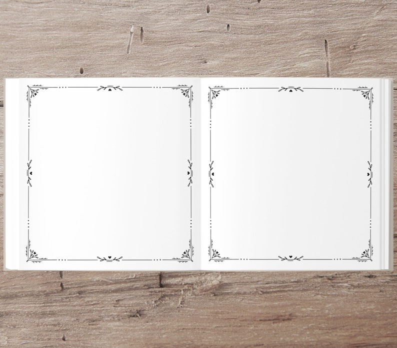 Puede incluir: Un libro blanco abierto, en blanco, con un borde negro decorativo alrededor de cada p&aacute;gina. El libro est&aacute; acostado sobre una superficie de madera.