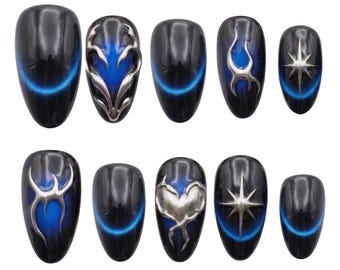 May include: A set of ten press-on nails featuring a black base with a vibrant blue cat-eye magnetic effect. Several nails are adorned with raised silver metallic 3D accents, including abstract shapes, a heart, and a four-pointed star design.