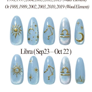 May include: Light blue Libra-themed nail art with gold detailing. Designs include suns, moons, stars, and the Libra scales symbol. Text on the nails reads "Libra (Sep23-Oct 22)" and "Rich Wife's Nails by Pinneacle".