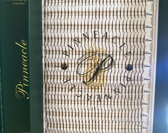 May include: A tray of dark brown individual eyelash extensions arranged in rows on a white backing. The tray features the text Pinneacle Lash Supply and includes labelled lengths ranging from 10mm to 20mm, with a central gold pineapple logo.