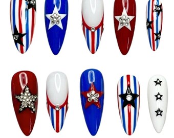 May include: A set of ten almond-shaped press-on nails featuring a patriotic theme. The designs include red, white, and blue vertical stripes, solid red, blue, and white bases, accented with silver star-shaped charms and embedded clear rhinestones.