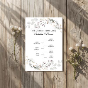 Könnte beinhalten: Eine Hochzeitszeitplan-Karte mit dem Text "WEDDING TIMELINE Catherine & Damon". Der Zeitplan umfasst Zeiten für Kirche, Erinnerungen, Abendessen und Tanz. Das Design zeigt florale Elemente in sanften Farben.