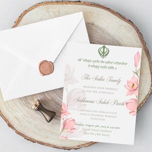 May include: Wedding invitation with floral accents and text in English and another language. The invitation is accompanied by a white envelope with a wax seal and a small, dark-colored stamp. The invitation is on a wooden slice.