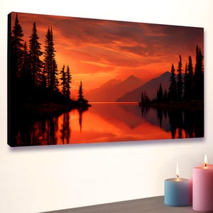 Könnte beinhalten: Rechteckiger Leinwanddruck eines Sonnenuntergangs über einem See, mit silhouettierten Bäumen und Bergen. Der Himmel ist ein leuchtendes Orange und Rot, das sich im Wasser spiegelt. Der Druck ist auf einem schwarzen Rahmen montiert.