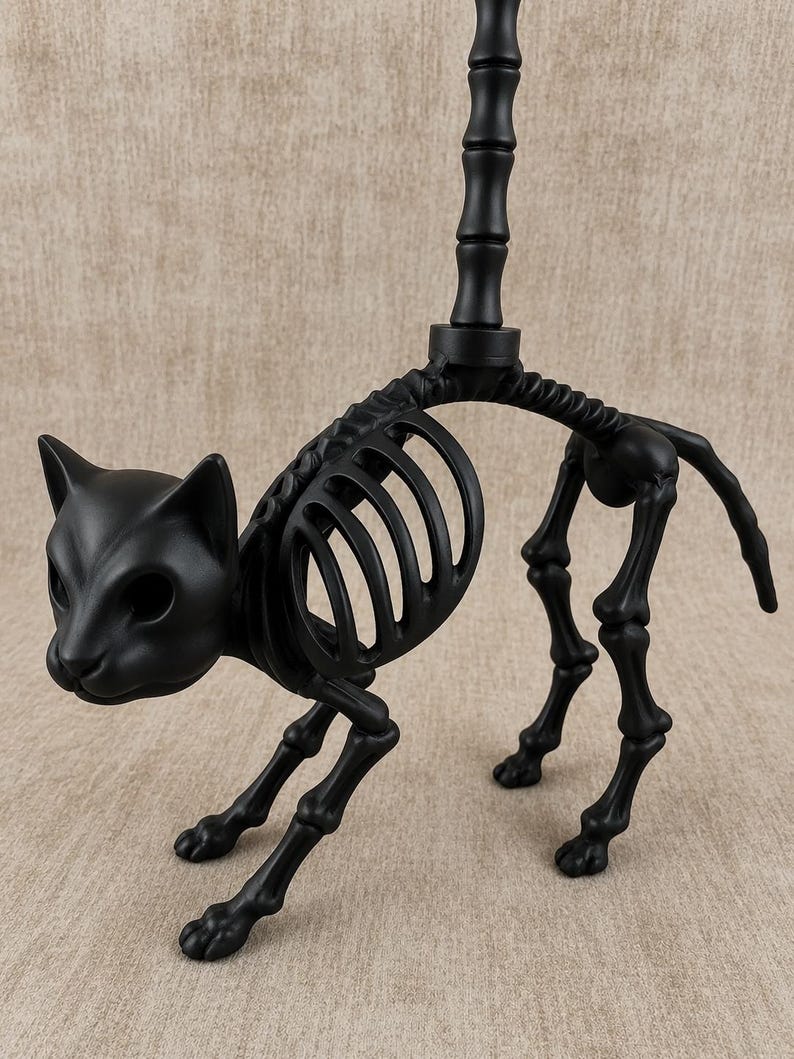 May include: A black cat skeleton figurine with a detailed rib cage, legs, and head. The cat is posed in a walking stance, with a vertical pole extending from its back. The figurine is made of a matte black material.