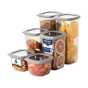 Può includere: Set di sei contenitori per alimenti in plastica trasparente con coperchi grigi. I contenitori sono di diverse dimensioni e sono riempiti con diversi snack, tra cui frutta secca, caramelle e orsetti gommosi. Il contenitore più grande ha un'etichetta che recita "Sehr Gut 93/100" e "Testsieger-Siegel.de".