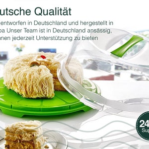 May include: A clear plastic cake dome with a green handle sits on top of a green cake plate with a white cake inside. The cake dome is designed to protect the cake from dust and insects. The cake plate is designed to hold the cake and make it easy to serve. The text "Deutsche Qualit&auml;t" is visible at the top of the image. The text "24/7 Support" is visible at the bottom of the image.