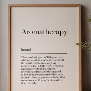 May include: A framed wall art print featuring the word Aromatherapy, the noun label, and a definition text describing the art of filling a space with scents like lavender and citrus to soothe the mind and lift the spirit in a light wood frame.