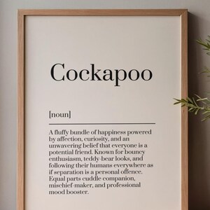 Może przedstawiać: Oprawiony wydruk ścienny z napisem Cockapoo dużą czarną czcionką szeryfową, po którym następuje etykieta noun w nawiasach oraz opisowy akapit definiujący rasę psa jako puszystą wiązkę szczęścia i profesjonalny poprawiacz nastroju.