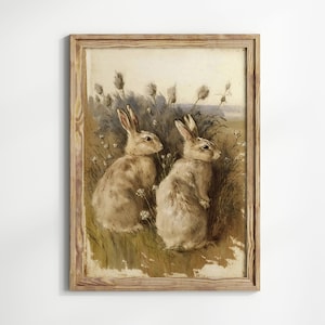 May include: A framed painting depicting two brown rabbits sitting in a field of tall grass and wildflowers. The rabbits are looking at each other.